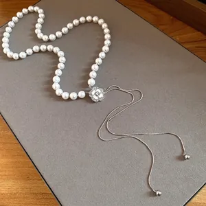 Elegant pearl necklace with diamond-set flower pendant and long silver tassels