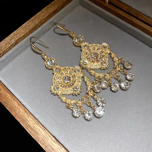 Detail view of retro palace style earrings with wheat ear pattern and rhinestones