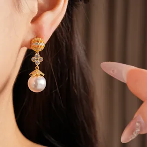 Detailed view of 18k gold plated clover earrings with zircon and large white pearl