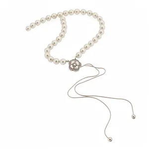 Elegant pearl beaded necklace featuring a crystal-studded camellia flower and tassels.