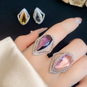 Close-up view of elegant teardrop-shaped zircon rings in purple and pink gem tones