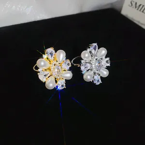 Close-up detail of sparkling zirconia and pearl flower rings with 14k gold plating