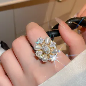 Close-up detail of a vintage floral pearl ring with sparkling zirconia and 14k gold plating