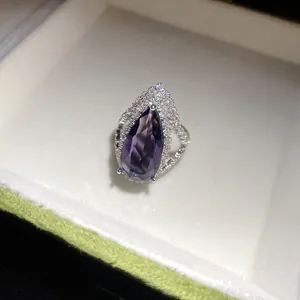 Detail view of a luxury teardrop purple zircon ring with silver-tone band
