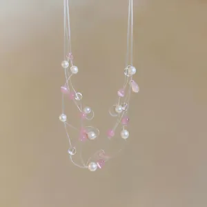 Collana multifilo con eleganti perle rosa e bianche su un cordoncino trasparente