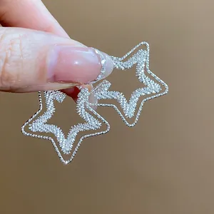 Dettaglio ravvicinato di alta qualità di orecchini a lobo a stella in argento a doppio strato