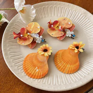 Vue détaillée de barrettes élégantes en forme d'orchidée et coquillage avec perles.