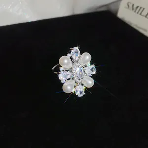 Detail of a 14k gold plated pearl ring with sparkling zircon floral design.