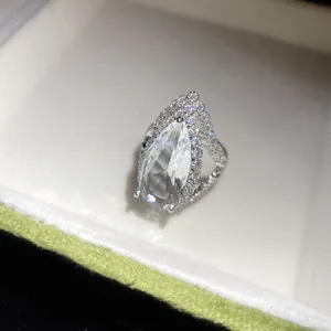 Close-up of a pear-cut zircon halo ring with silver adjustable band design