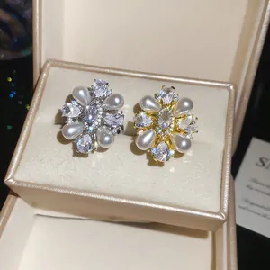Detailed view of 14k gold plated pearl and zircon rings in elegant floral design