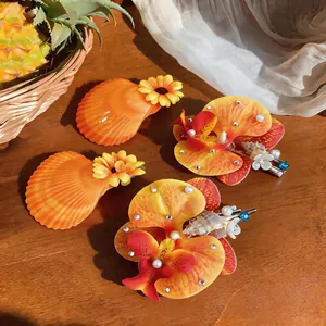 Vue détaillée de pinces à cheveux tropicales avec fleurs, coquillages et perles