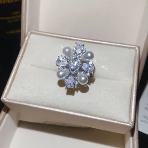 Detailed view of a floral zircon and pearl ring nestled in a premium jewelry box.