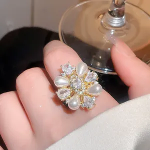 Elegant 14k gold plated pearl and zircon flower ring shown worn on a finger for detail.