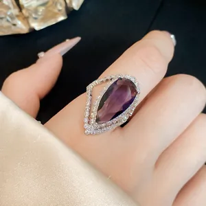Close-up of elegant pear-cut purple zircon ring with shimmering crystal halo