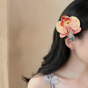 Pince à cheveux orchidée élégante avec perles et strass portée par un mannequin