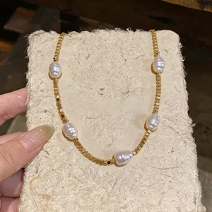 Close-up of 18k gold plated beaded necklace with baroque pearls on textured card