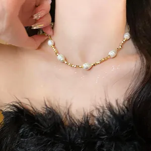 Detail view of 18k gold plated beaded choker necklace with white baroque pearls