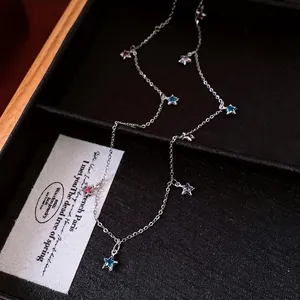 Elegant silver chain necklace with colorful glass star charms displayed in luxury tray