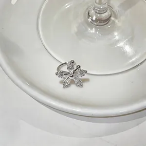 Close-up detail of a silver zircon flower ear cuff on a white ceramic plate background