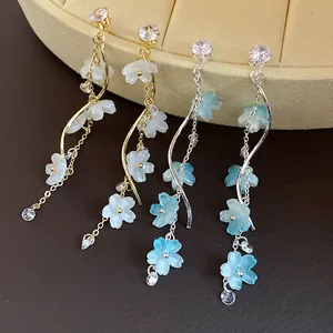 Close-up of elegant long tassel earrings with zircon and frosted flower petals