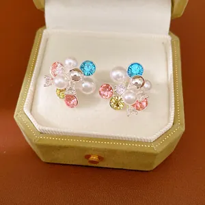 Close-up detail of silver needle flower cluster earrings with colorful zircons and pearls