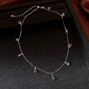 Detailed macro view of a vintage silver necklace featuring colorful glass star-shaped charms.