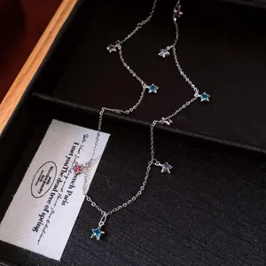 Detail of vintage glass star fringe necklace with colorful charms on black tray