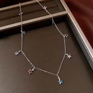 Detailed macro view of a vintage silver necklace with colorful glass star charms on a tray