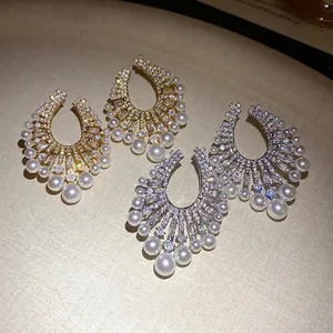 Elegant vintage palace style horseshoe earrings with sparkling zircons and pearls on tray