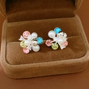 Detail of colorful flower cluster earrings with pearls and rhinestones in a velvet box