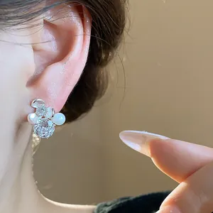 Detailed close-up of elegant flower stud earring featuring shimmering zircons and soft pearls