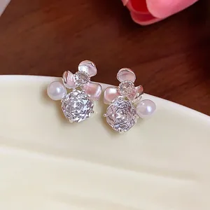 Macro view of elegant flower stud earrings with sparkling zircons and delicate white pearls