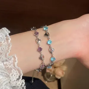 Elegant Korean style heart-shaped crystal bracelets in purple and blue colors on a wrist.