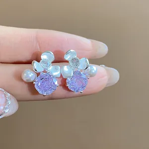 Detailed close-up view of elegant purple zircon flower earrings with delicate white pearls