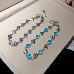 Elegant heart-link bracelet with sparkling purple and blue gemstones in a jewelry box