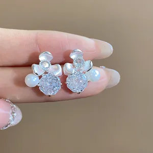 Detailed close-up of exquisite zircon flower stud earrings with elegant white pearl accents