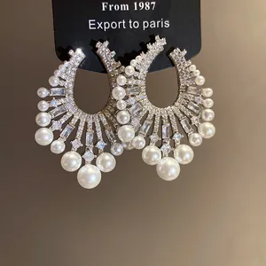 Close-up of vintage French style earrings with pearls and shimmering cubic zirconia