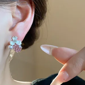 Detailed macro close-up of a silver flower stud earring featuring pink zircon and pearl
