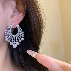Close-up detail of luxury vintage palace style drop earrings with white pearls and sparkling zircons