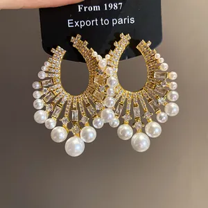 Close-up detail of vintage French style gold hoop earrings with pearls and zircons