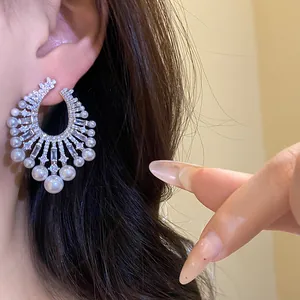 Detailed close-up showing vintage zircon and pearl fan-shaped hoop earrings on ear model