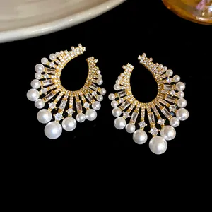 Macro view of vintage French style gold earrings with pearls and brilliant zircons
