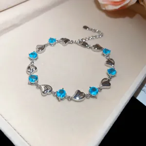 Detailed macro view of heart-shaped silver bracelet featuring sparkling blue gemstones