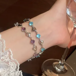 Sparkling heart link bracelet with purple and blue round crystals on wrist