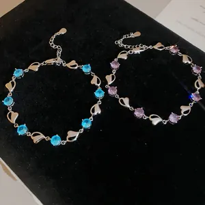 Detailed view of heart-link bracelets featuring vibrant blue and purple rhinestones