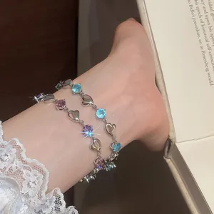 Detailed view of colorful heart-shaped crystal bracelets styled on a woman's ankle