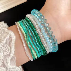 Close-up of a 10-piece Bohemian beaded bracelet set featuring blue and green tones