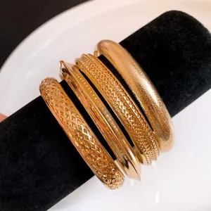 Vista macro dettagliata di bracciali rigidi dorati retrò su espositore nero lusso