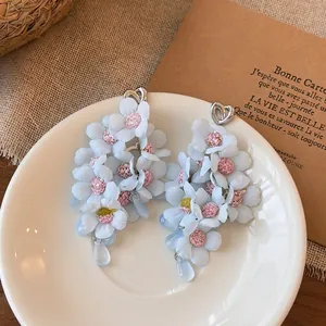 Close-up of elegant blue fabric flower tassel earrings with cute heart details