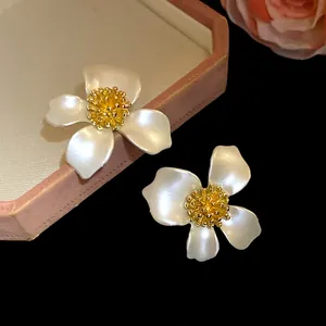 Dettaglio di eleganti orecchini a lobo a forma di fiore bianco in stile vintage